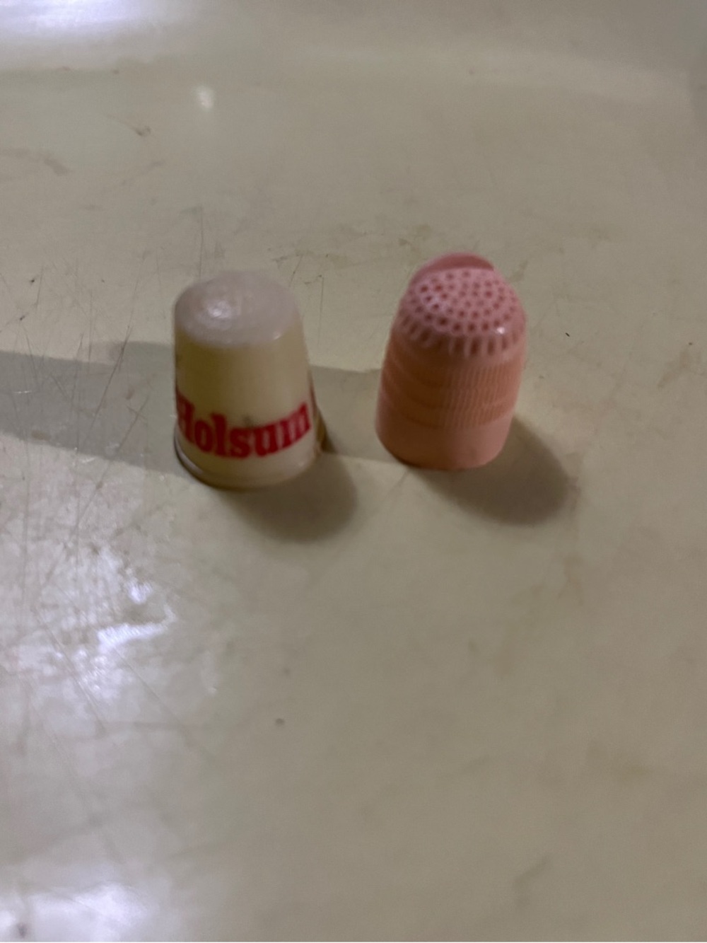 VINTAGE COLLECTIBLES “HOLSOM BREAD” & PINK OPEN FINGER SEWING THIMBLES (SET OF 2
